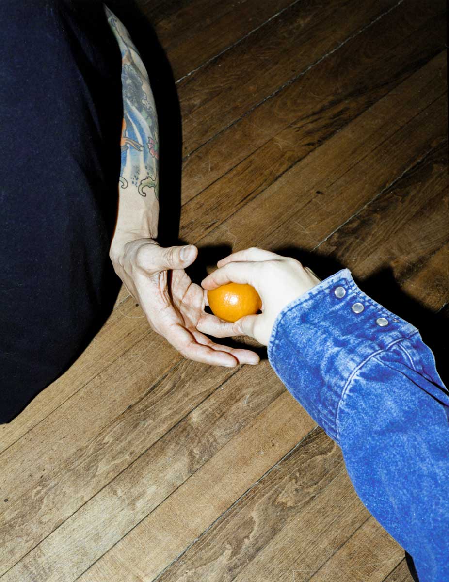 photo of Less San Miguel and me, DP, of our hands; we are passing an orange