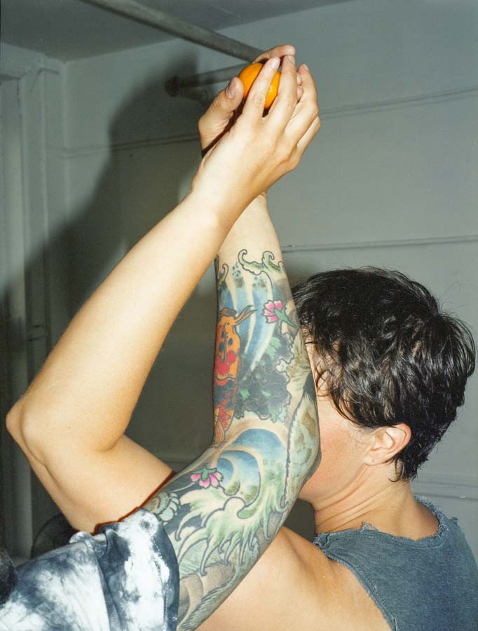photo of Less San Miguel and me, DP by Reza Rezaï; we're holding an orange, our arms twisting around one another