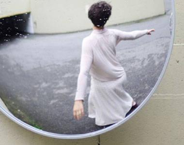 refelction of me dancing in a parking garage mirror